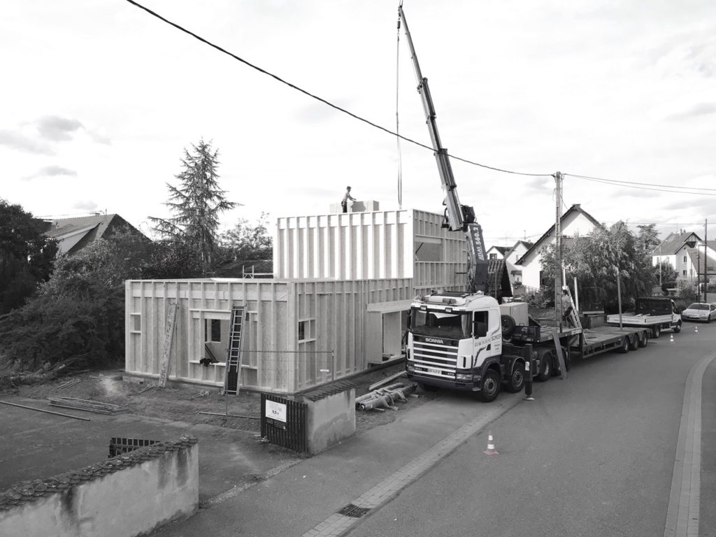 opération de levage pour la pose de l'ossature en bois d'une maison contemporaine