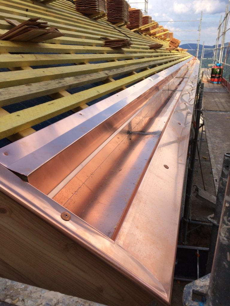 Détail de la toiture réalisée pour un chalet en bois avec travaux de cuivrerie