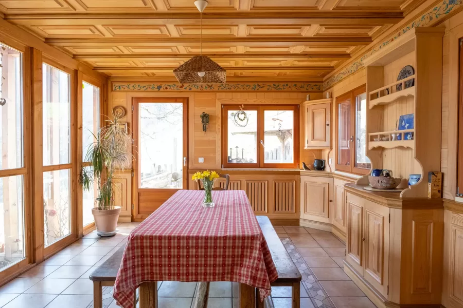 Salle à manger en bois de chêne et épicéa. Vaisselier ouvert, grand table à manger, plafond en bois