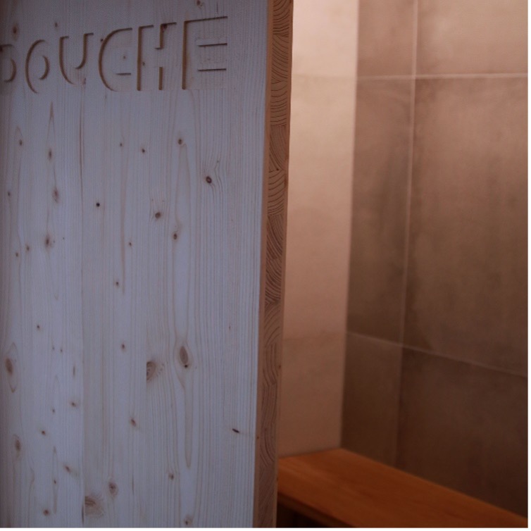 Porte coulissante en bois avec le mot "douche" en signalétique gravée 